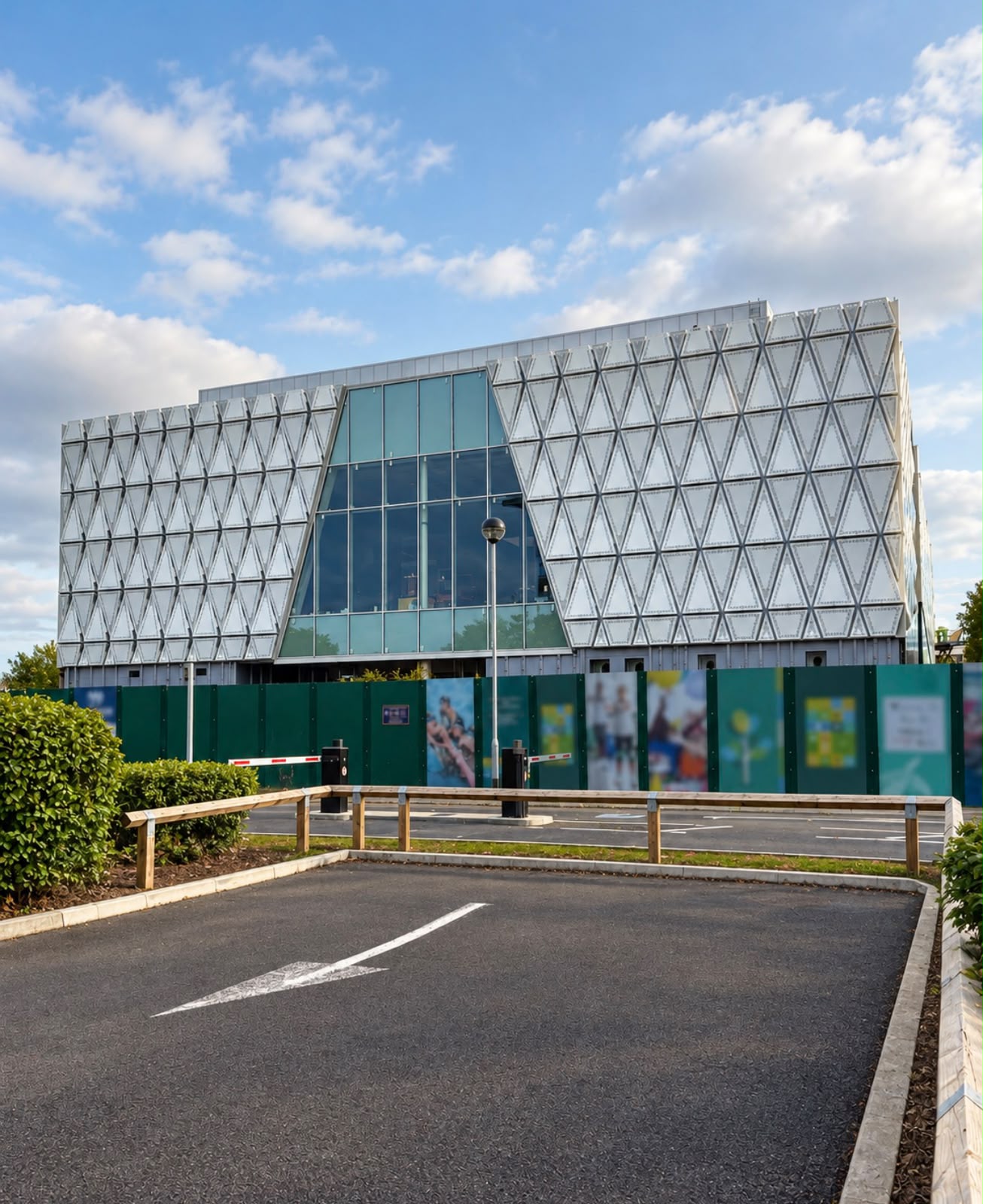 Front elevation: triangular perforated aluminium panels either side of the full-height glazed entrance