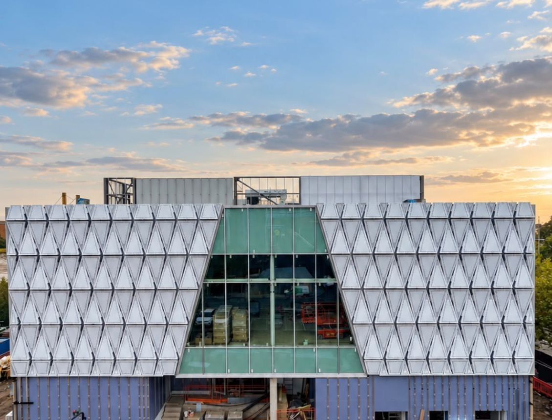 Newport Leisure and Wellbeing Centre at sunset, with our triangular aluminium façade panels around the glazed entrance